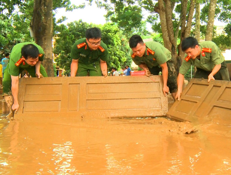 Công an dầm mình trong bùn lầy giúp người dân khắc phục hậu quả lũ lụt